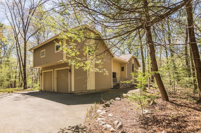 9 Stonehedge Way, Granby, CT 06060 - view of side of home featuring an attached garage and aphalt driveway