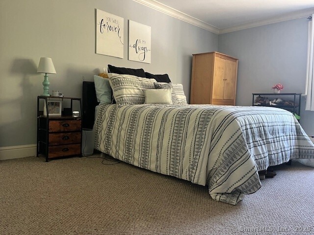 carpeted bedroom featuring baseboards and ornamental molding