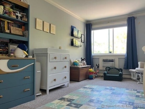 carpeted bedroom with ornamental molding, a baseboard heating unit, and a baseboard radiator
