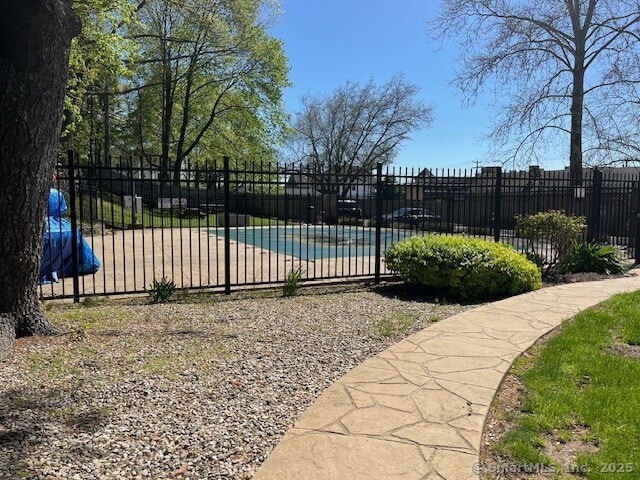 view of gate featuring fence and a covered pool