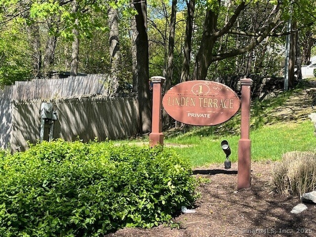 community / neighborhood sign featuring fence