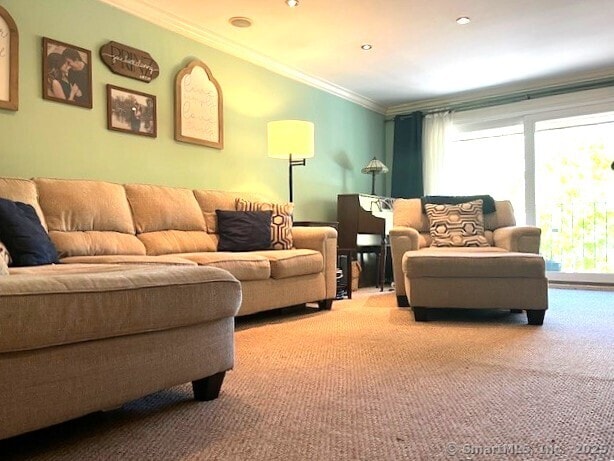 living room featuring carpet floors, crown molding, and plenty of natural light