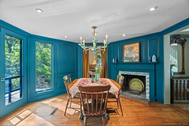 66 Hedlund Rd, East Haddam, CT 06423 - dining space with a chandelier, a decorative wall, light wood-style floors, and a stone fireplace