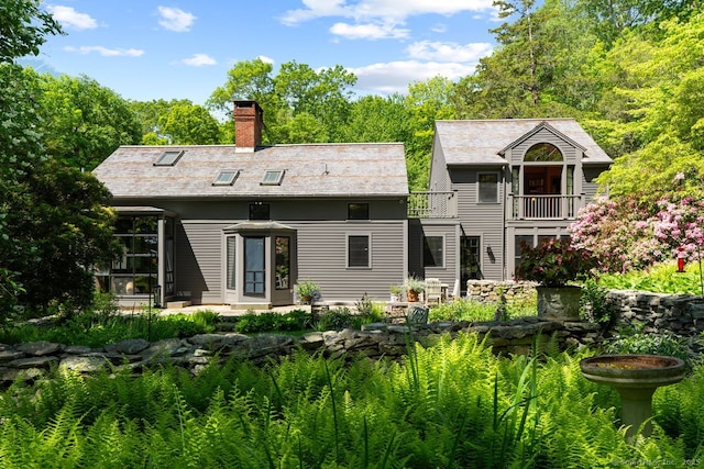 66 Hedlund Rd, East Haddam, CT 06423 - back of property with a balcony, a chimney, and a patio area