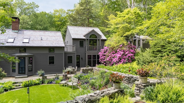 66 Hedlund Rd, East Haddam, CT 06423 - back of property with a balcony, a chimney, a high end roof, and a lawn