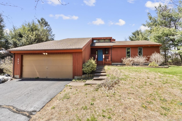 mid-century home featuring driveway and a garage