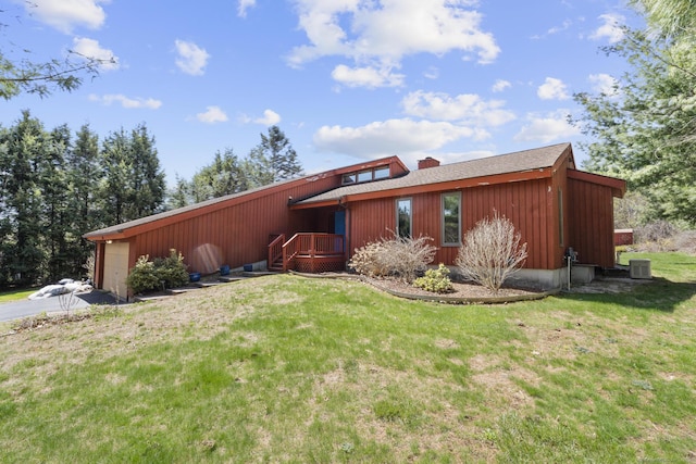 exterior space featuring a front yard, a shingled roof, an attached garage, and aphalt driveway