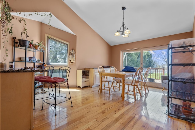 dining room featuring light wood finished floors, vaulted ceiling, and a healthy amount of sunlight