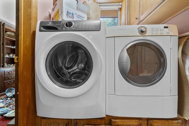 clothes washing area featuring cabinet space and independent washer and dryer