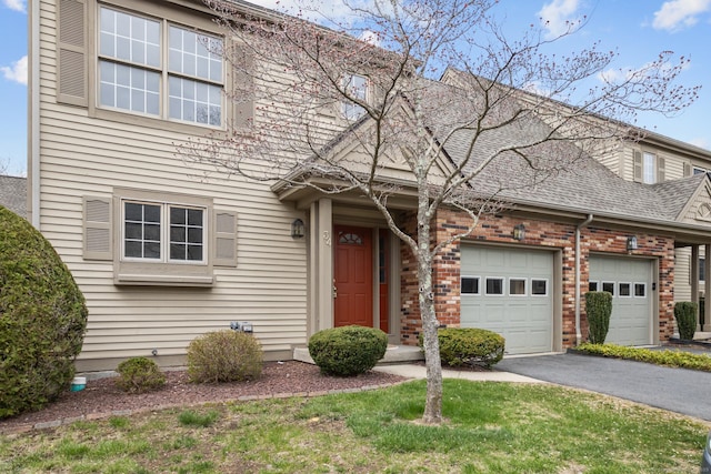 view of front facade featuring driveway, brick siding, and a garage
