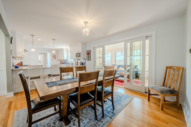 dining space with french doors, light wood-type flooring, and recessed lighting