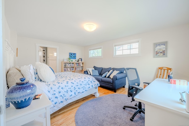 bedroom featuring light wood-style floors and ensuite bath