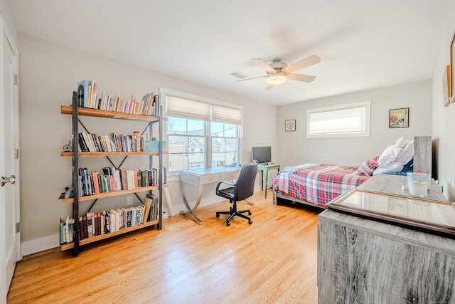 bedroom featuring wood finished floors, ceiling fan, visible vents, and baseboards