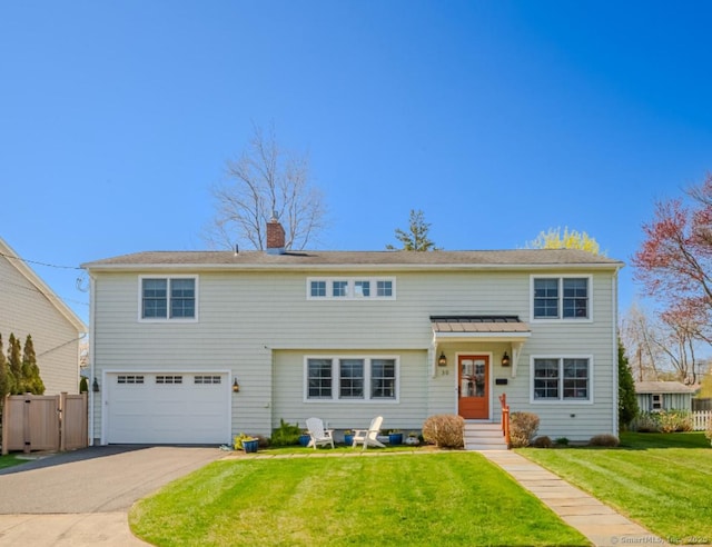 view of front of property featuring aphalt driveway, a chimney, a front yard, fence, and a garage