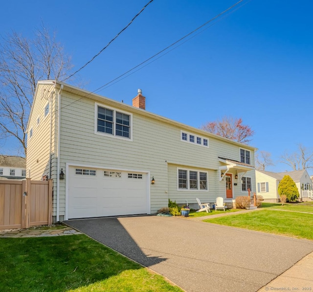 view of front of property with a front yard, a garage, driveway, a chimney, and fence