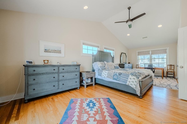 bedroom with lofted ceiling, visible vents, light wood finished floors, and multiple windows