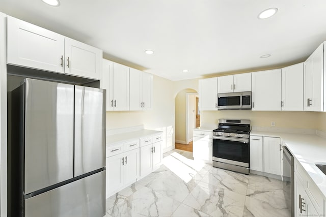 576 Main St, Somers, CT 06071 - kitchen featuring white cabinetry, stainless steel appliances, arched walkways, and marble finish floor