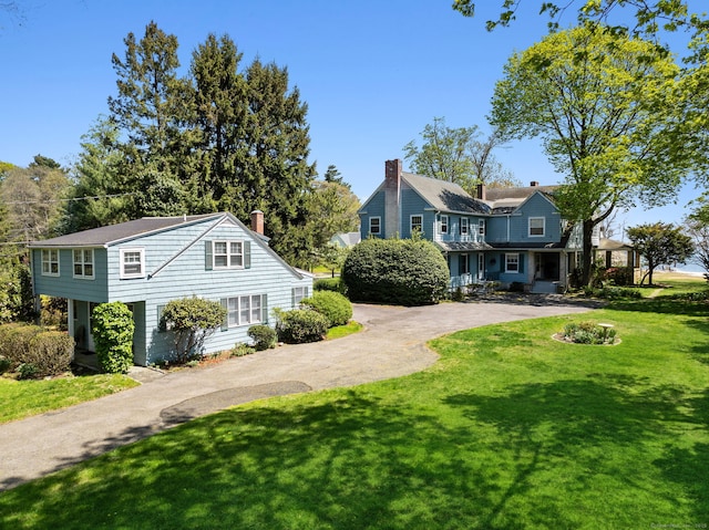 86 Wallacks Dr, Stamford, CT 06902 - view of property exterior with a chimney, a yard, and driveway