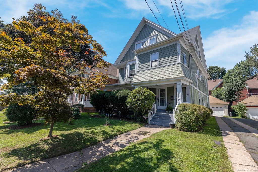 37 Center St, West Haven, CT 06516 - view of front facade featuring a detached garage, a porch, and a front yard