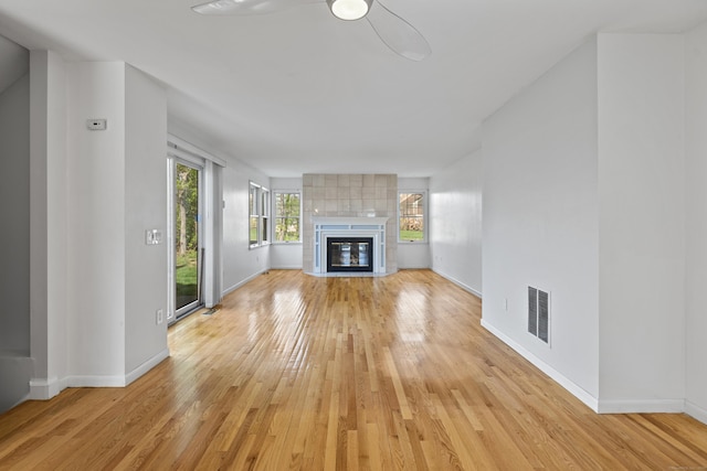 75 Brittania Rd Unit 75, Danbury, CT 06811 - unfurnished living room with visible vents, light wood-style floors, baseboards, a tiled fireplace, and a ceiling fan
