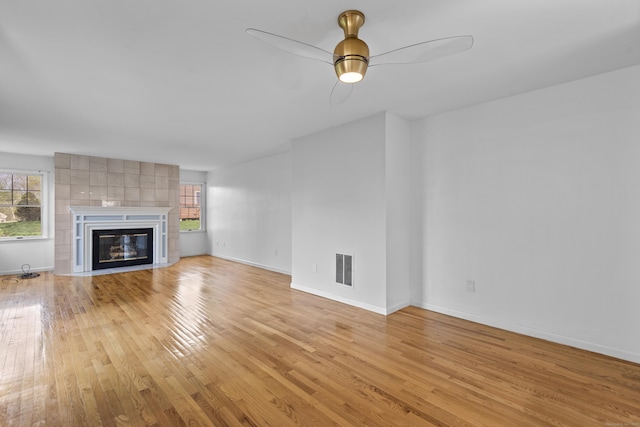 75 Brittania Rd Unit 75, Danbury, CT 06811 - unfurnished living room featuring baseboards, visible vents, a tile fireplace, and light wood-style floors