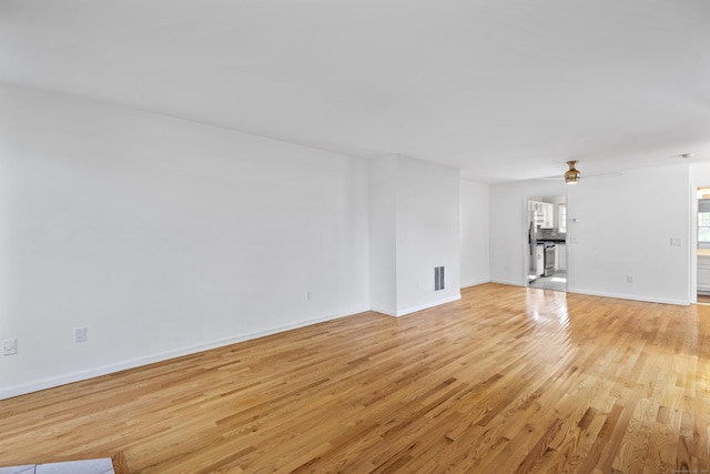 75 Brittania Rd Unit 75, Danbury, CT 06811 - unfurnished living room featuring visible vents, light wood finished floors, ceiling fan, and baseboards