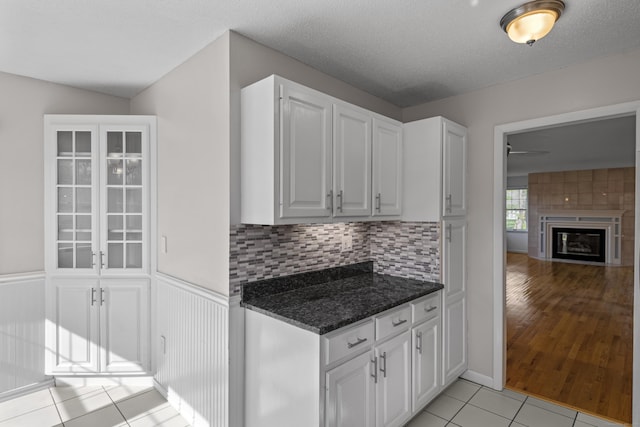 75 Brittania Rd Unit 75, Danbury, CT 06811 - kitchen with light tile patterned floors, dark stone counters, white cabinets, and backsplash