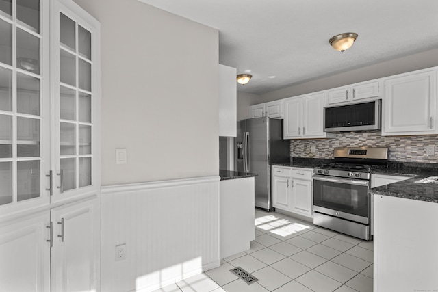 75 Brittania Rd Unit 75, Danbury, CT 06811 - kitchen featuring light tile patterned flooring, a wainscoted wall, white cabinets, tasteful backsplash, and stainless steel appliances