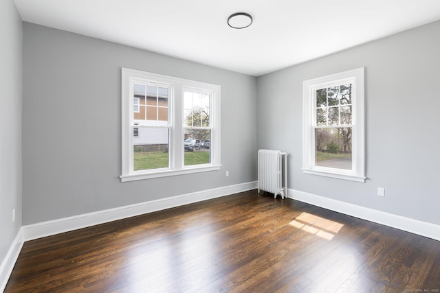60 Mill St, New Britain, CT 06051 - empty room with baseboards, radiator heating unit, a healthy amount of sunlight, and dark wood-style flooring