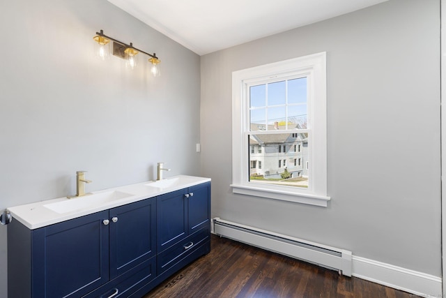 60 Mill St, New Britain, CT 06051 - bathroom with double vanity, wood finished floors, a baseboard heating unit, and a sink