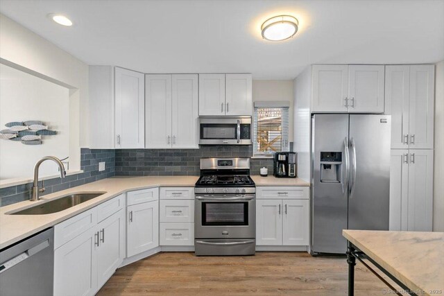 kitchen featuring light countertops, a sink, white cabinetry, and stainless steel appliances