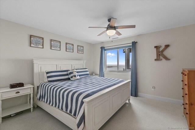 bedroom featuring baseboards, a ceiling fan, and light carpet