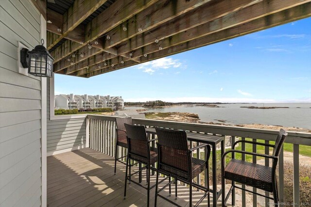 wooden terrace featuring a water view