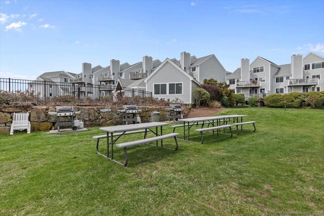 view of property's community featuring a residential view, fence, and a lawn
