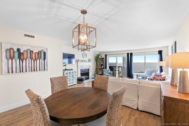 1 Mansfield Grove Rd Apt 206, East Haven, CT 06512 - dining room with a chandelier, wood finished floors, a fireplace, and baseboards