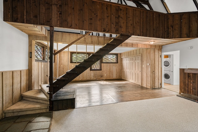 302 Ferry Rd, Old Lyme, CT 06371 - basement with stacked washer / dryer, wooden walls, stairs, wood finished floors, and carpet