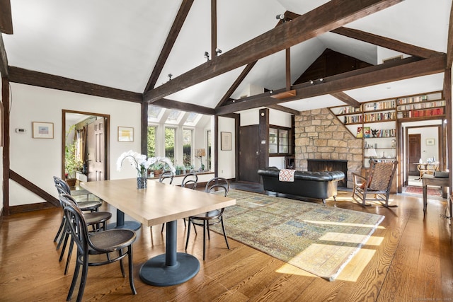 55-69 Sawmill Rd, Branford, CT 06405 - dining area featuring beam ceiling, wood finished floors, high vaulted ceiling, and a stone fireplace