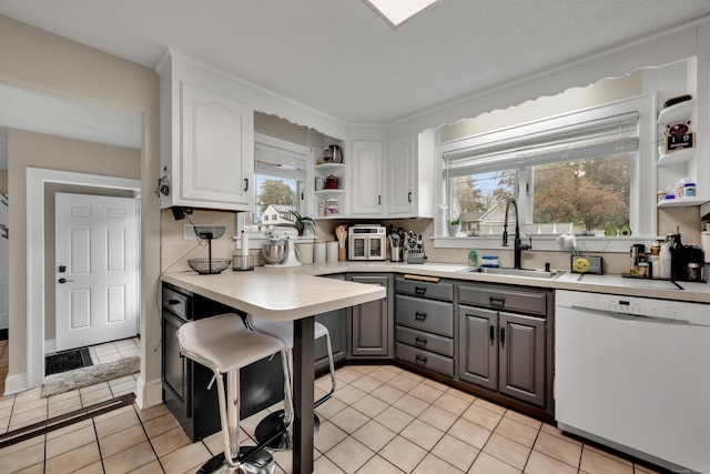 kitchen with white cabinets, white dishwasher, open shelves, and a sink