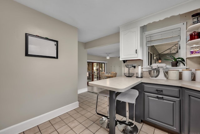 kitchen featuring light countertops, white cabinetry, light tile patterned flooring, and gray cabinetry