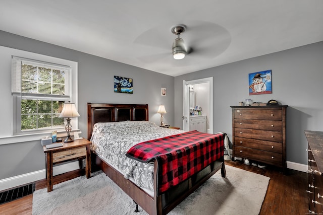 bedroom featuring visible vents, a ceiling fan, baseboards, and wood finished floors