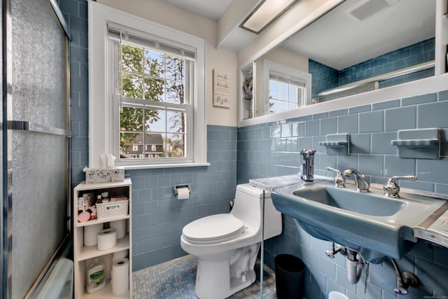 full bath featuring tile patterned flooring, a wealth of natural light, toilet, and tile walls