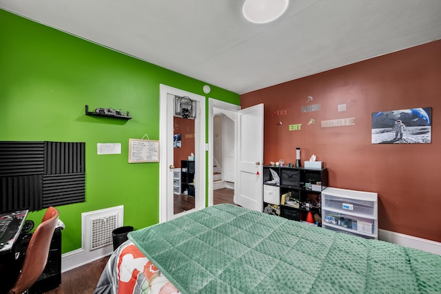 bedroom featuring baseboards, dark wood-style floors, and visible vents