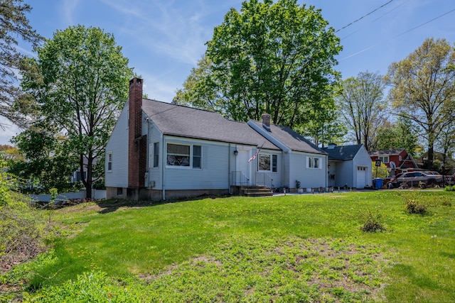 ranch-style home featuring entry steps, an attached garage, a chimney, and a front yard