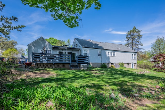 rear view of property with a lawn, a wooden deck, and central air condition unit