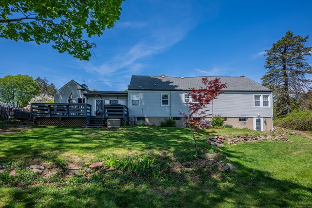 rear view of house featuring a deck and a lawn