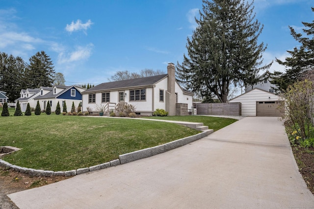 view of front facade with a chimney, an outbuilding, a garage, a front lawn, and concrete driveway