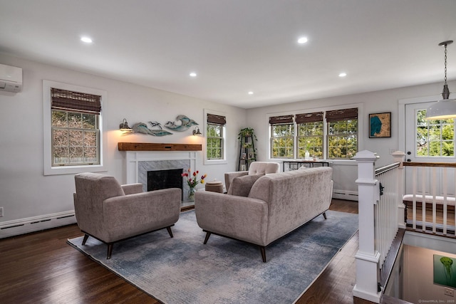 living room with recessed lighting, a baseboard heating unit, and dark wood-style flooring