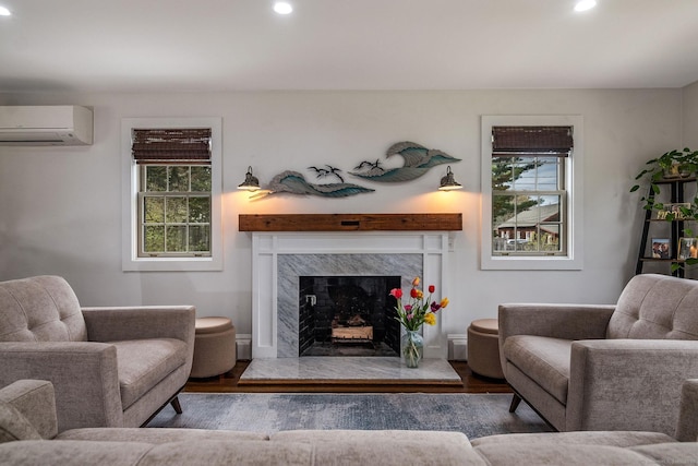 living room featuring a fireplace, recessed lighting, wood finished floors, and a wall mounted air conditioner