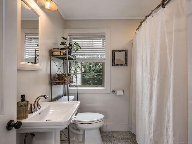 bathroom with crown molding, a sink, baseboards, toilet, and a shower with shower curtain