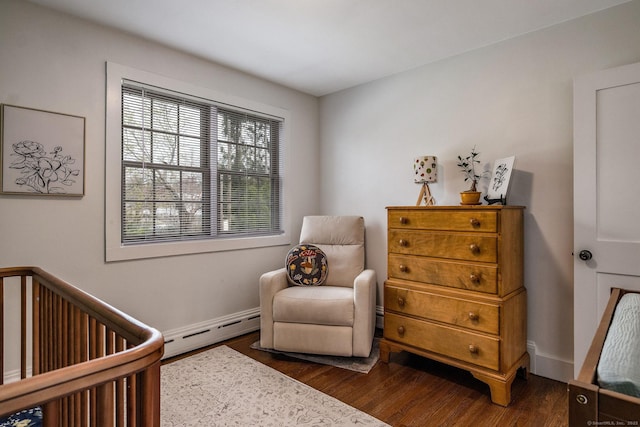 bedroom with a baseboard radiator, a nursery area, and dark wood-style floors